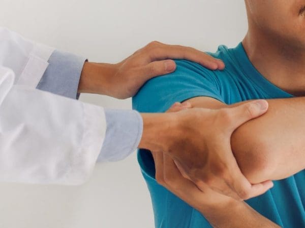 A medical provider assesses a patient's right shoulder and elbow.