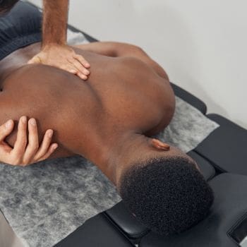 A male laying on his stomach receiving a chiropractic adjustment.
