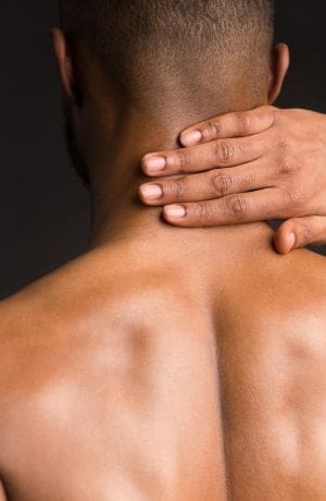 Photo of a man holding his neck