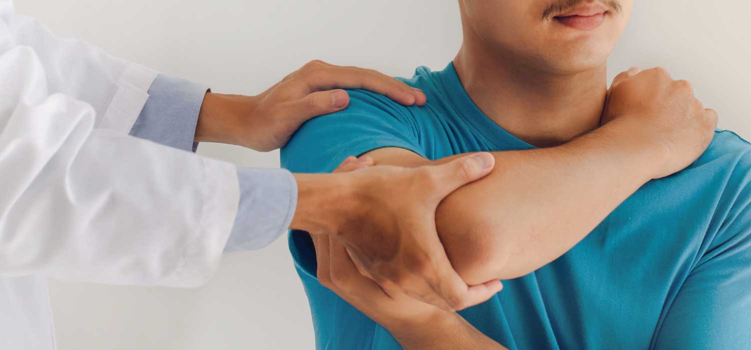 A doctor examines a male patient's right shoulder and elbow.